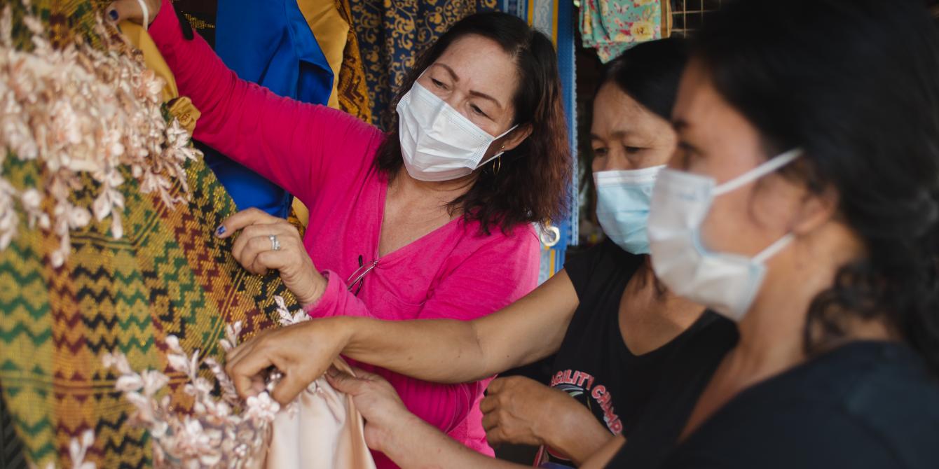 Sarah Dilangelan, President of the Women’s Federation of Datu Abdullah Sangki, Maguindanao, shows the finished Inaul gown to the two women in Datu Abdullah Sangki, Maguindanao. These women are part of the cash-for-work support program by Oxfam and Rural Development Institute of Sultan Kudarat, with the support from The People of Government and Japan and UN Women. (Photo: Princess Tarroza/Oxfam)